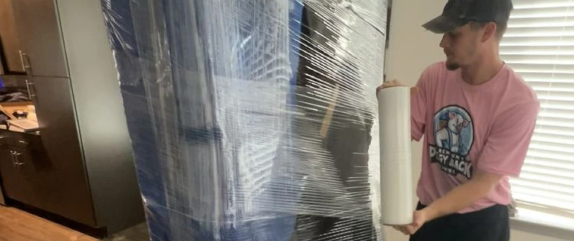 a piggyback premium moving crew member wrapping furniture