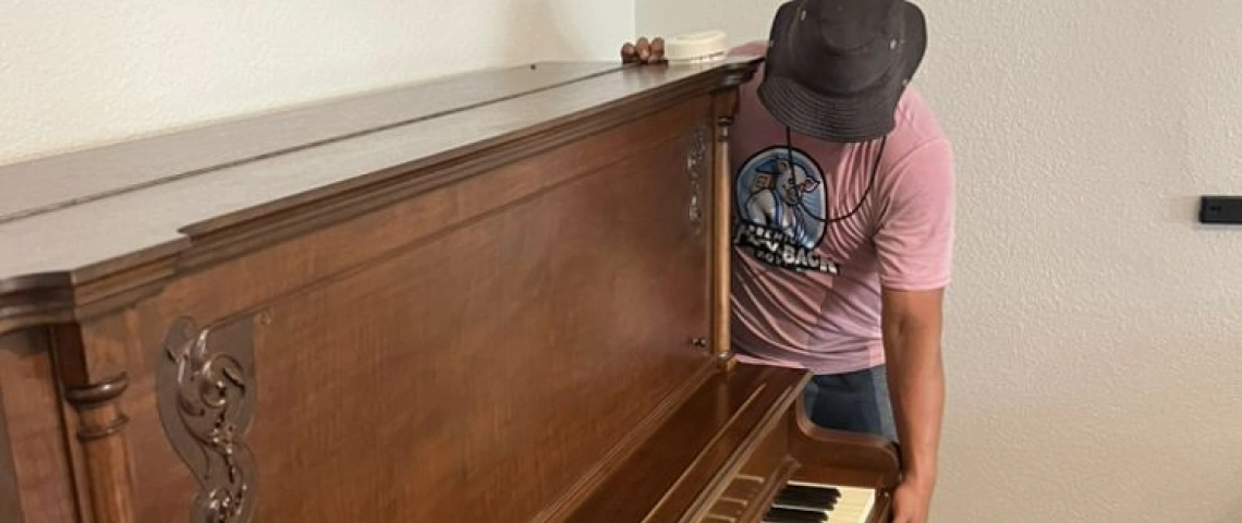 pigggyback premium moving crew member with a piano