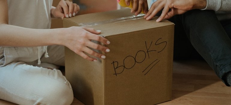 a woman packing a moving box